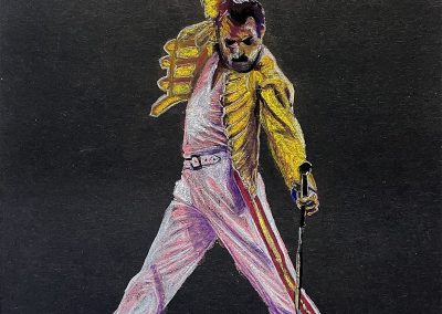 Pastel drawing on black paper of Freddie Mercury performing on stage in his yellow leather jacket.